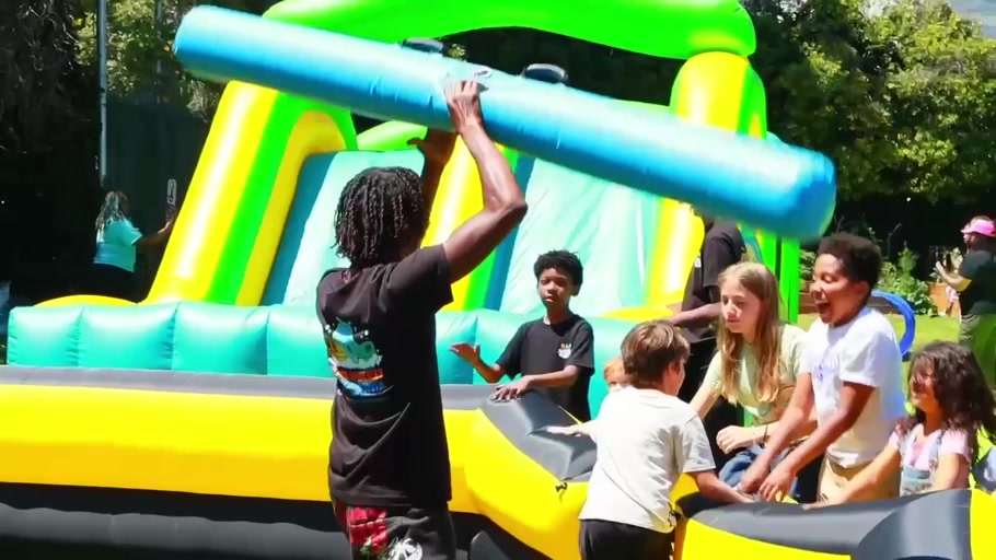 D.N.A. participants helping each other through an inflatable challenge